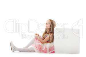 Dreamy little girl posing with cube in studio
