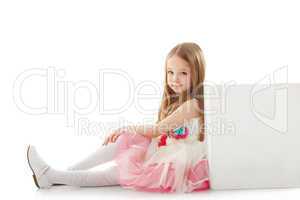 Adorable little girl posing leaning on cube