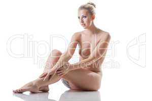 Cheerful smiling woman posing naked in studio