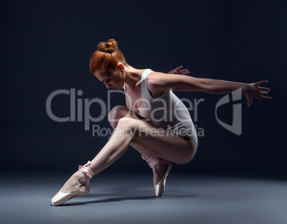 Graceful slender ballerina dancing in studio