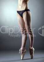 Muscular slender dancer's legs in pointes