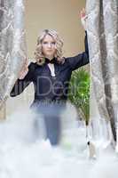 Image of charming blonde draws curtains