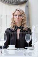 Portrait of young attractive girl sitting at table