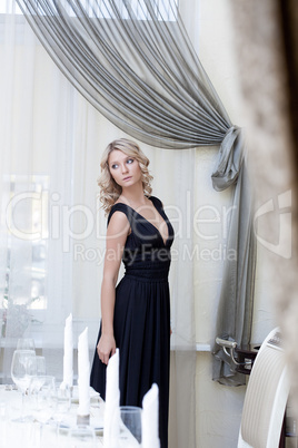Luxury young woman posing in hotel's restaurant