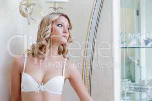 Slim curvy woman posing in white bra, close-up