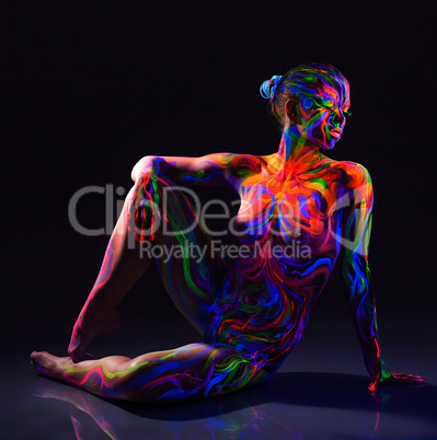 Seductive naked dancer with colorful UV make-up