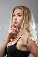 Charming curly blonde posing in studio, close-up