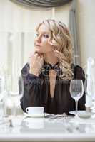 Portrait of curly blonde posing in restaurant