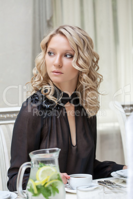 Beautiful young model posing sitting at table