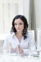 Portrait of attractive brunette sitting at table