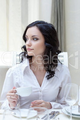 Beautiful young brunette drinking coffee