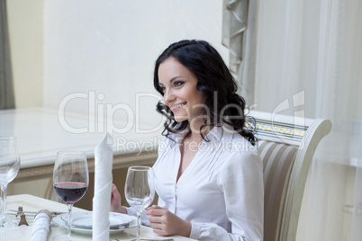 Smiling young brunette posing in hotel restaurant