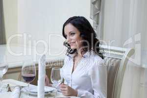 Smiling young brunette posing in hotel restaurant