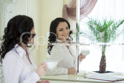 Portrait of cheerful brunette looking in mirror