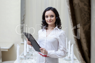 Portrait of smiling waitress posing with menu