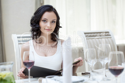 Curvy slender brunette sitting at restaurant table
