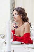 Charming brunette drinking wine in restaurant