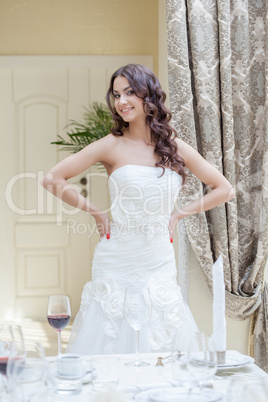 Happy young bride posing in hotel room