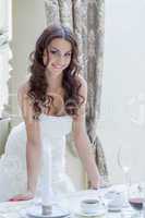 Charming young bride posing near banquet table