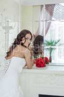 Attractive smiling bride posing in front of mirror