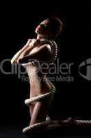 Young nude woman posing with rope