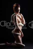 Sexy naked model with rope isolated on black