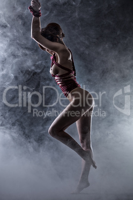 Graceful nude woman tied with rope in studio