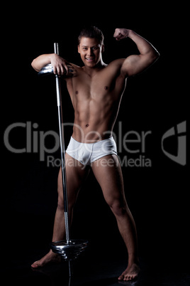 Smiling strong man posing with barbell in studio