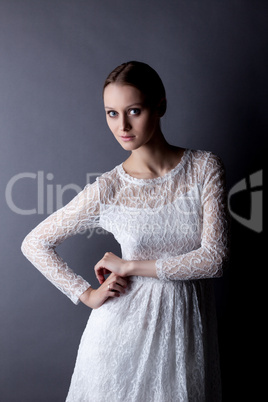 Portrait of fragile young girl in white lace dress