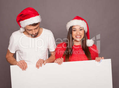 young couple holding billboard in christmas