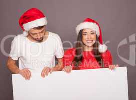 young couple holding billboard in christmas