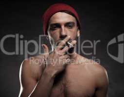 shirtless man smoking a cigarette