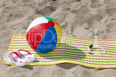 Strandmatte mit Flip Flops und Sonnenbrille