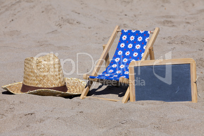 Strandliege, Strohhut und eine Schiefertafel