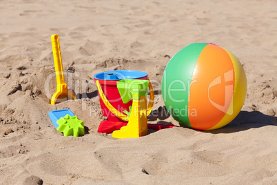 Buntes Spielzeug und Ball am Strand
