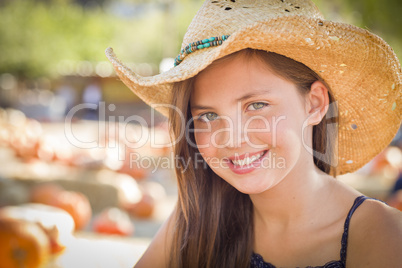preteen girl portrait wearing cowboy hat at pumpkin patch