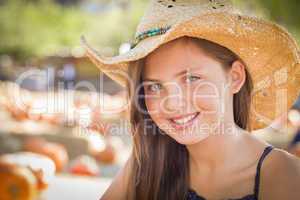preteen girl portrait wearing cowboy hat at pumpkin patch