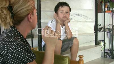 Little boy looking at his mother while smoking cigarette