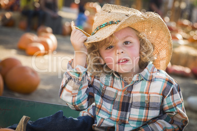 Young boy in cowboy hat at pumpkin patch