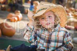 Young boy in cowboy hat at pumpkin patch