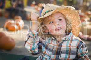 little boy in cowboy hat at pumpkin patch