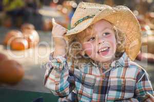 little boy in cowboy hat at pumpkin patch