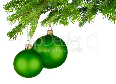 zwei grüne christbaumkugeln hängen am tannenzweig