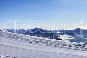 ski slope and snowy mountain in haze