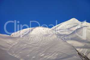 off-piste slope and blue clear sky in nice winter morning