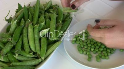 Female hands peeling peas