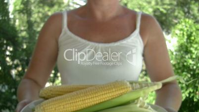 woman holding plate with corn