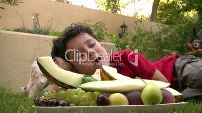 Little boy eating fruit at picnic outdoors