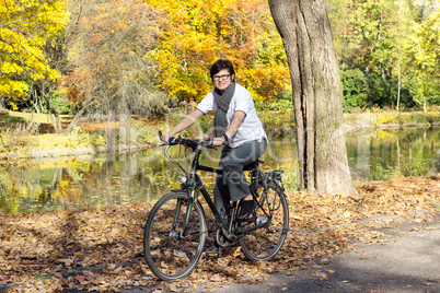woman on bicycle in autumn park