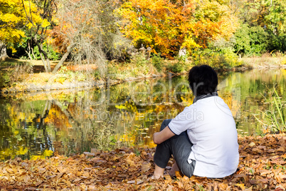 woman sitting in autumn leaves